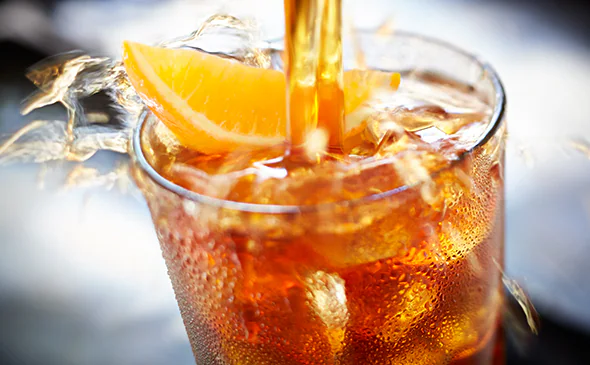 Refreshing Bellini Peach Raspberry Iced Tea served cold with ice and fruit slices