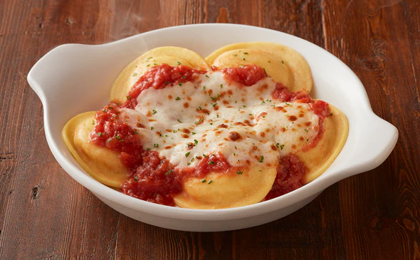 Cheese ravioli pasta served with marinara sauce and parmesan cheese