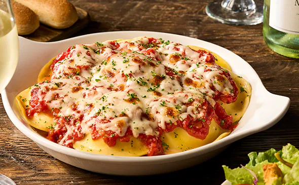 Cheese ravioli pasta filled with ricotta and parmesan, topped with marinara sauce and fresh basil