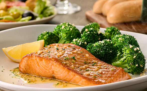 Herb-grilled salmon fillet served with lemon butter sauce and fresh seasonal vegetables