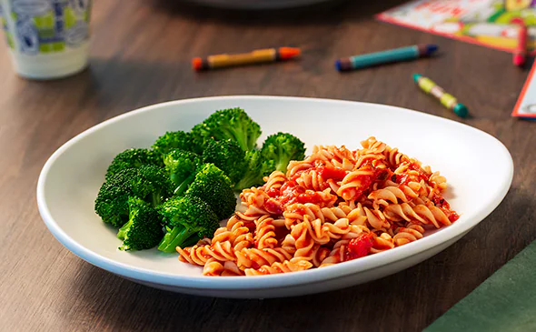 Kids vegetarian rotini pasta with marinara sauce served hot and fresh