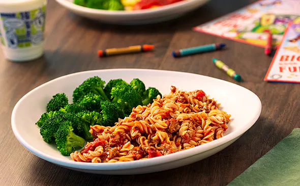 Rotini pasta with meat sauce kids meal served hot and topped with parmesan