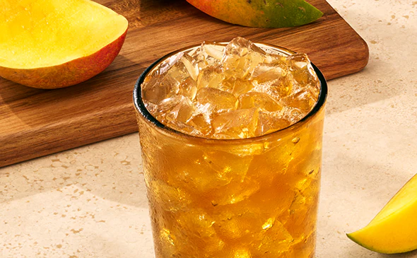 Refreshing Mango Passion Fruit Iced Tea served cold with ice and lemon slice