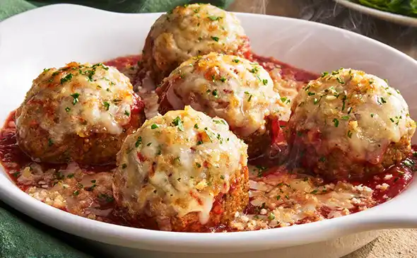 Classic Meatballs Parmigiana topped with melted cheese and marinara sauce