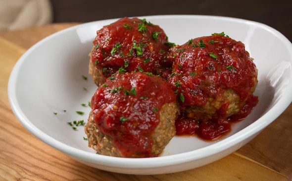 Side of Italian meatballs served with marinara sauce and parmesan cheese