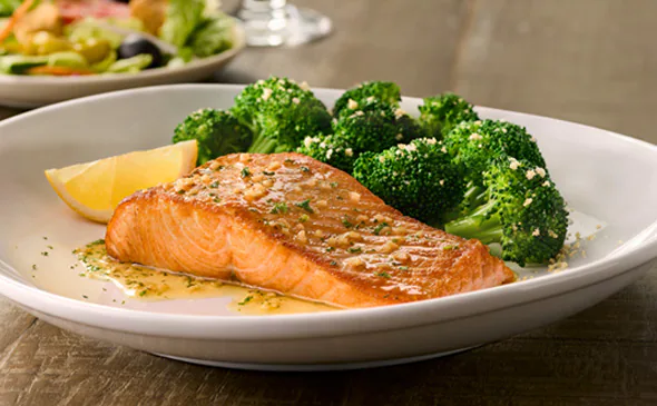 Herb-grilled salmon fillet served with garlic butter and fresh herbs