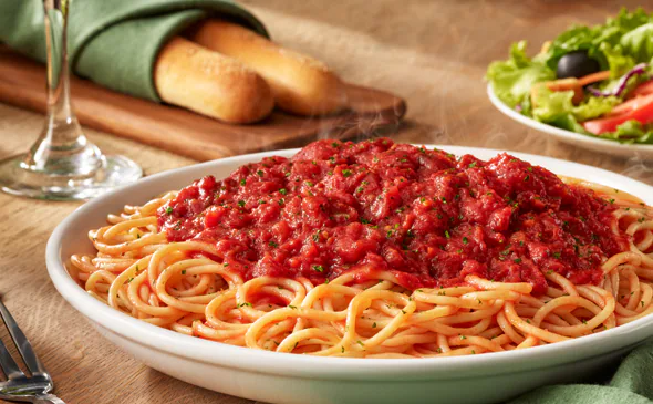 Vegetarian spaghetti with marinara sauce topped with fresh basil and parmesan cheese