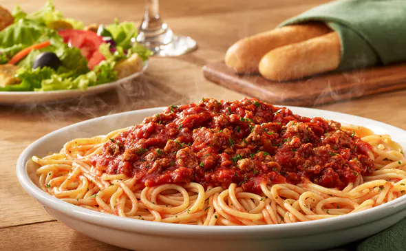 Spaghetti with rich Italian meat sauce topped with parmesan cheese and fresh herbs