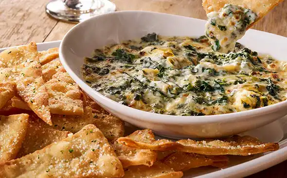 Creamy spinach artichoke dip served warm with toasted bread or chips