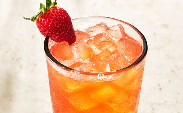 Refreshing Strawberry Passion Fruit Limonata drink served cold with ice and lemon slice