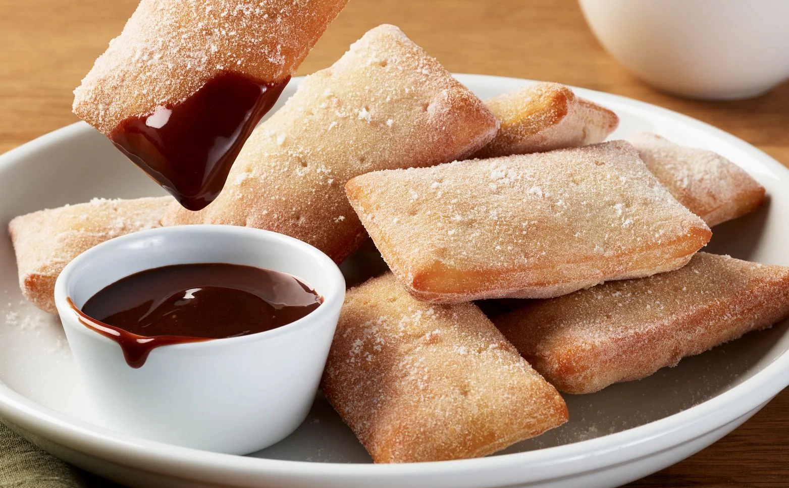 Warm vegetarian Italian doughnuts dusted with sugar and served with chocolate sauce