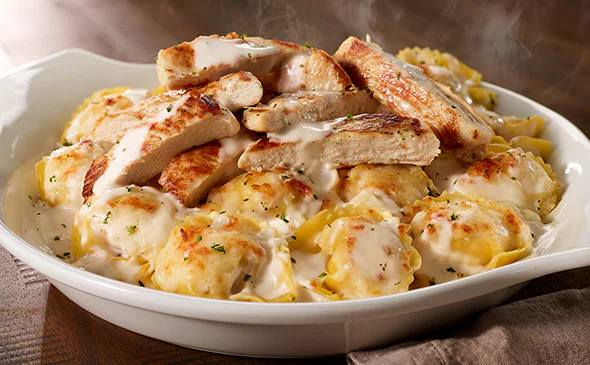Chicken tortelloni alfredo pasta in creamy parmesan sauce with grilled chicken and fresh herbs