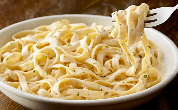 Vegetarian fettuccine alfredo pasta in creamy parmesan sauce garnished with fresh parsley