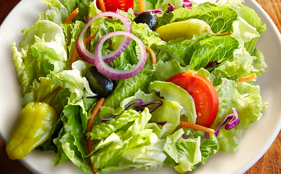 Famous house salad without croutons served with fresh lettuce, tomatoes, and dressing