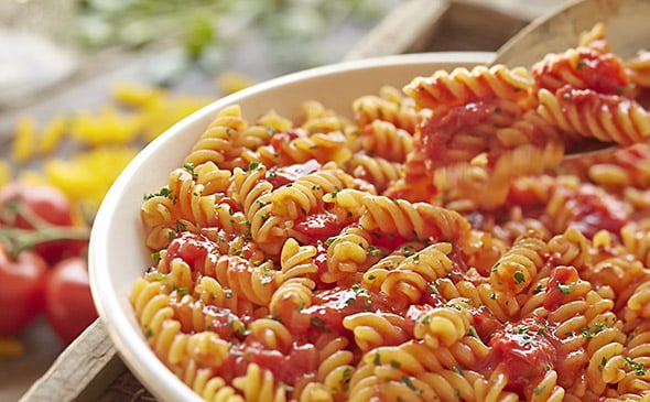 Rotini pasta with marinara sauce served hot and topped with parmesan cheese
