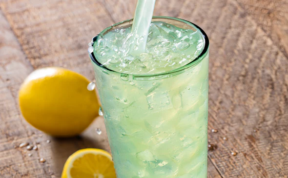 Classic lemonade served cold with ice cubes and fresh lemon slices