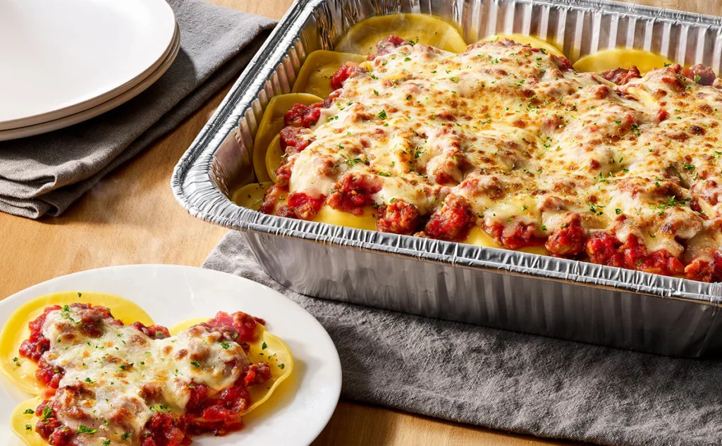 Olive Garden Cheese Ravioli with Marinara or Meat Sauce Family Meal featuring cheese-filled ravioli topped with Italian cheeses and tomato sauce.