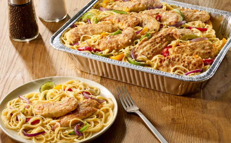 Olive Garden Chicken Scampi Family Meal with creamy garlic scampi sauce, bell peppers, red onions, and angel hair pasta served in a pan.