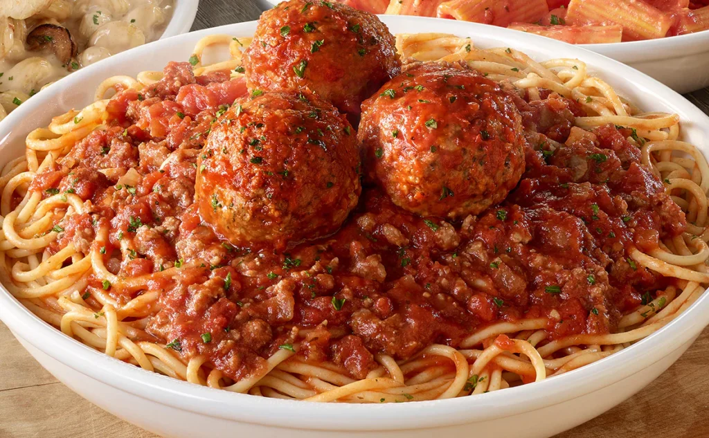 Olive Garden Spaghetti & Meatballs entrée with spaghetti, three meatballs, and marinara or meat sauce on a white plate.